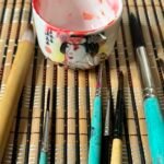 Brushes and sake cup on a bamboo mat